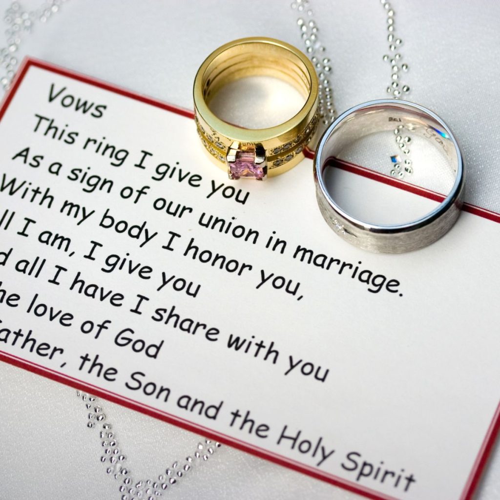 Card with wedding vows and wedding rings.