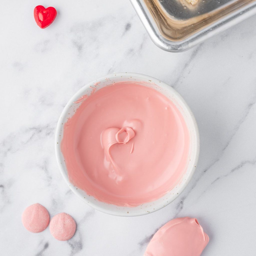 Melted pink chocolate in a bowl.