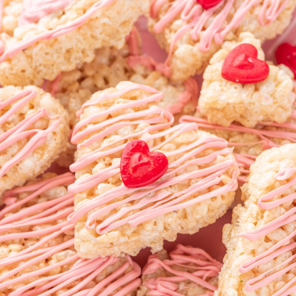 Heart shaped rice krispie treats with pink chocolate topping.