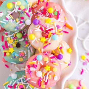 Mini pink and blue donuts with sprinkles.