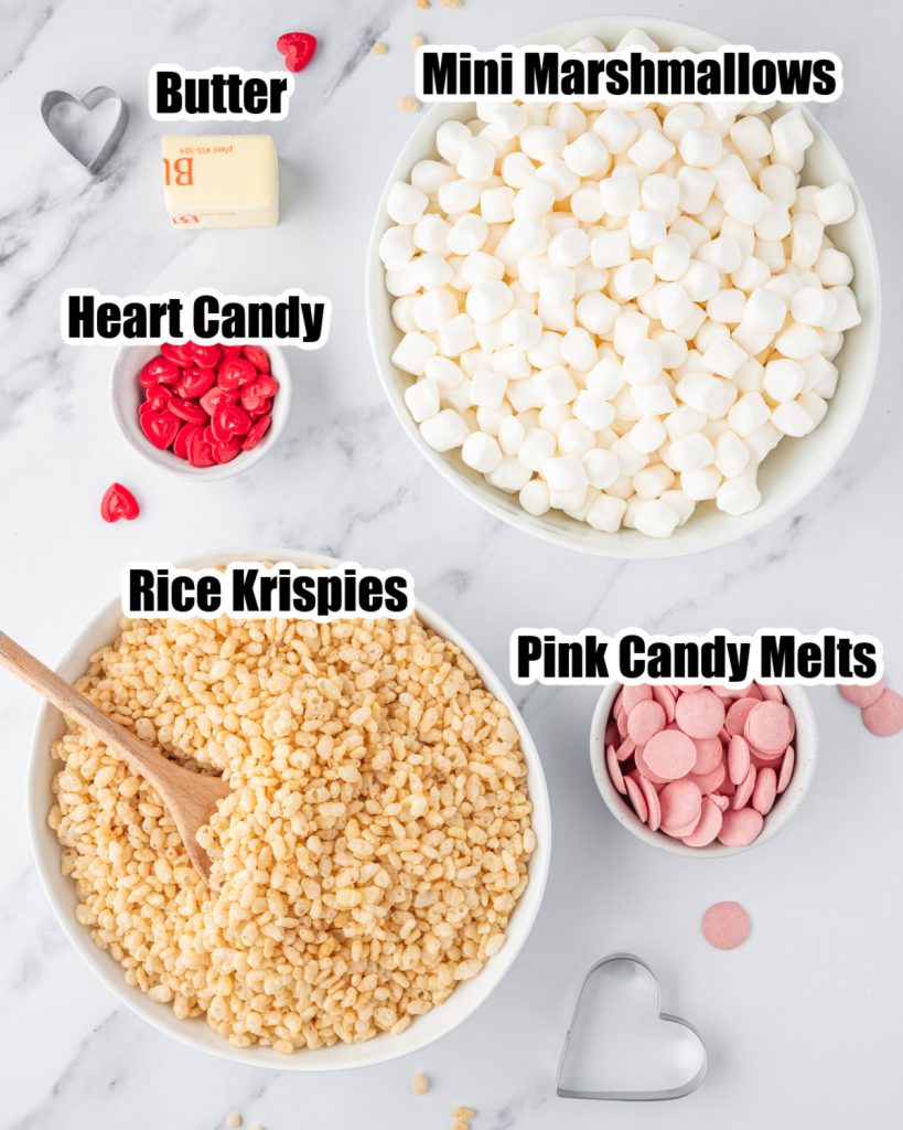 Bowl of mini marshmallows, Rice Krispies, butter, and pink candy melts. 