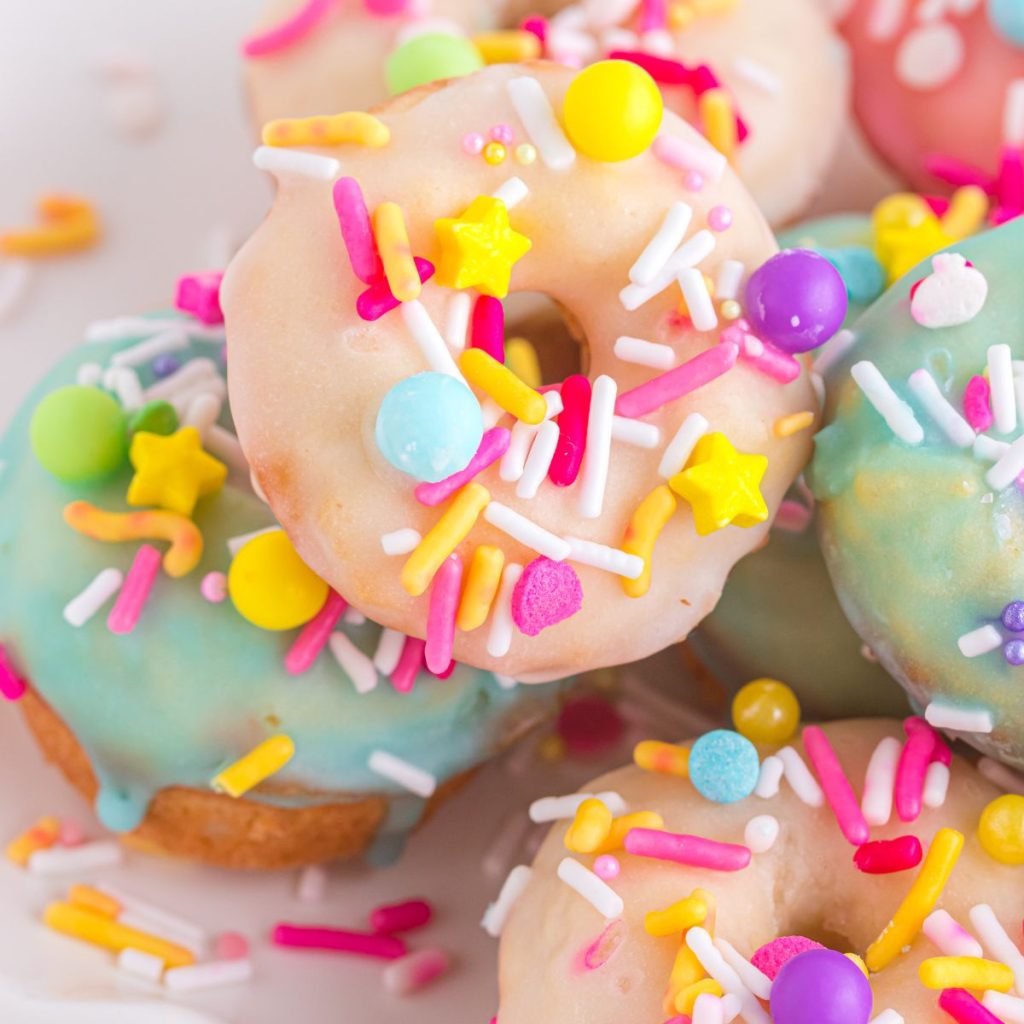 Pink and blue mini donuts with sprinkles. 