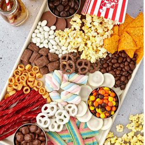Tray with popcorn, candy, chips, and chocolate covered pretzels.