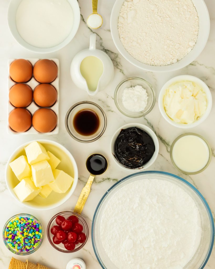 Eggs, bowl of flour, sugar, vanilla, food coloring, and milk. 