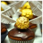 Chocolate cupcake with gold ball with wings.