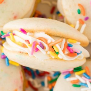 Vanilla sandwich cookie with icing and rainbow sprinkles.