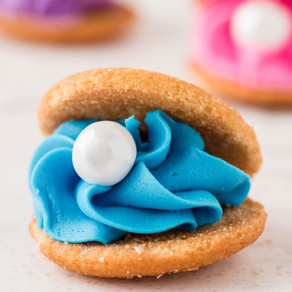 Two wafer cookies filled with blue frosting and white candy.