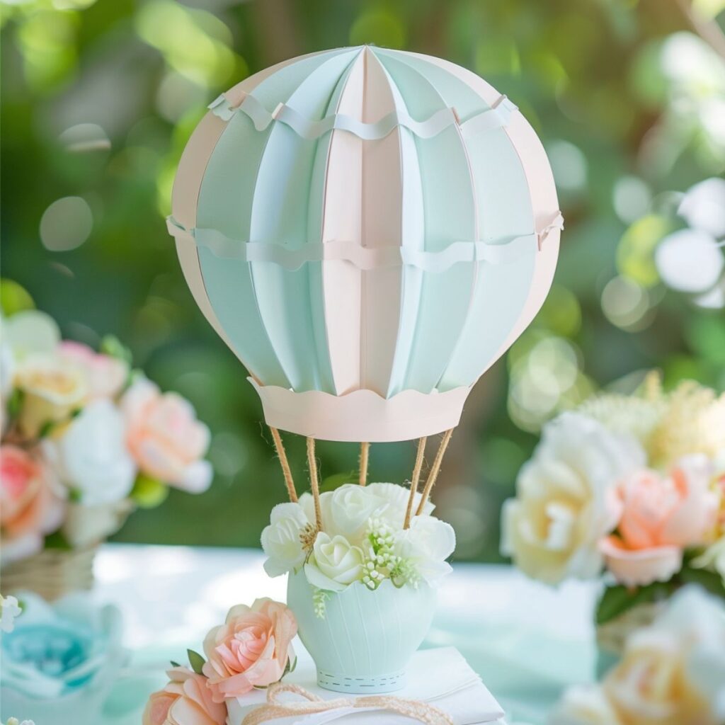 A pink and blue small hot air balloon on a table with flowers. 