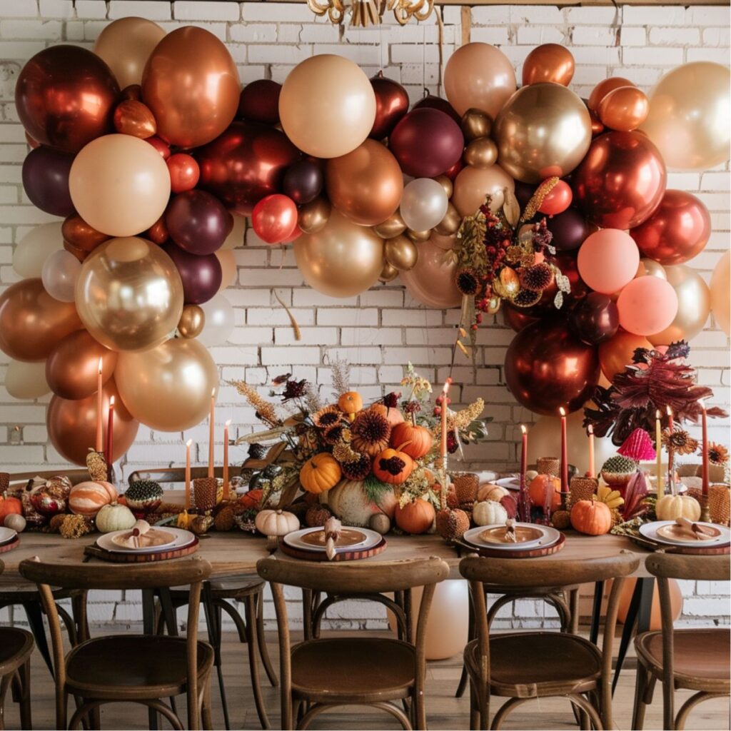 Fall party table with a gold and maroon colored balloon arch.