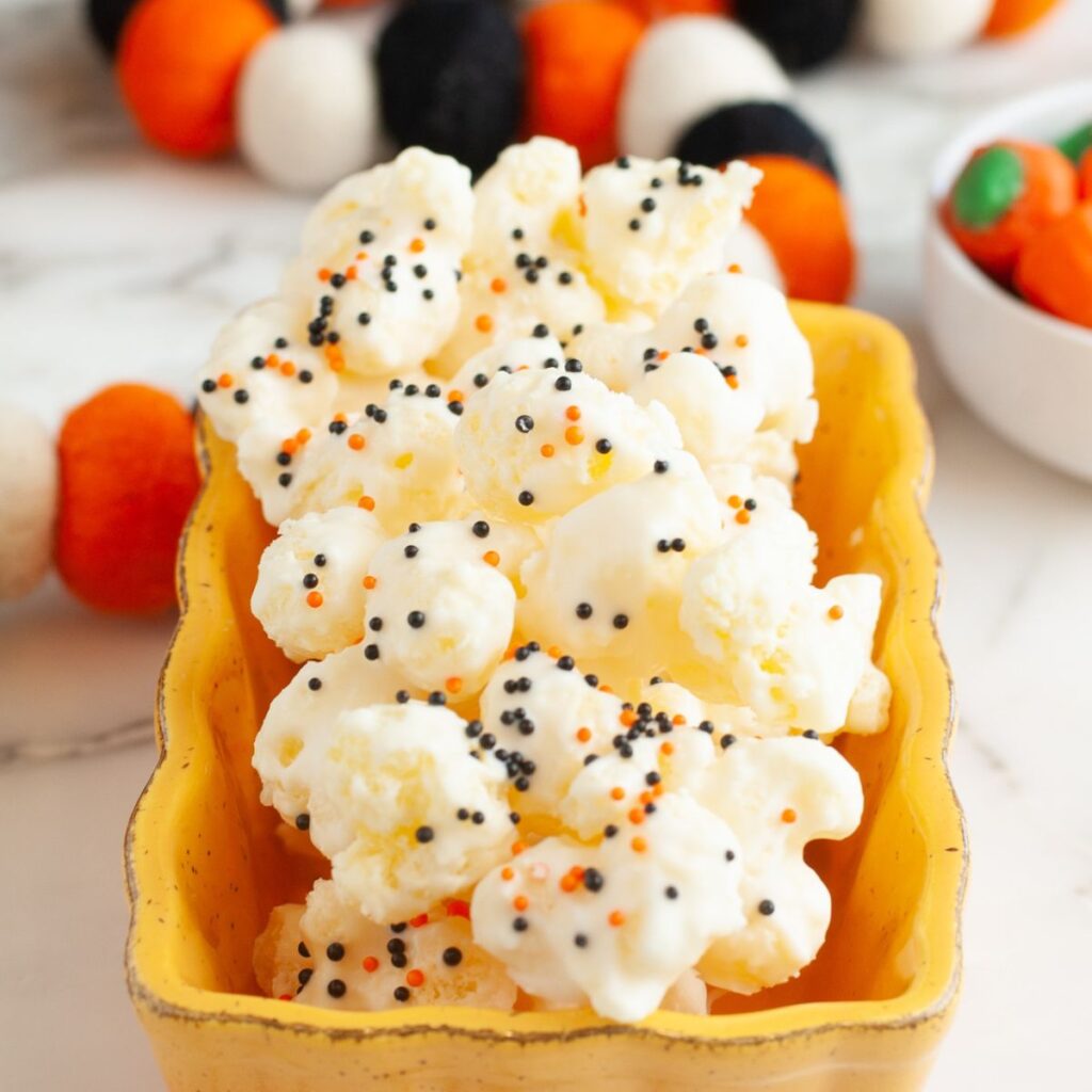 Orange bowl with white chocolate covered puffcorn.