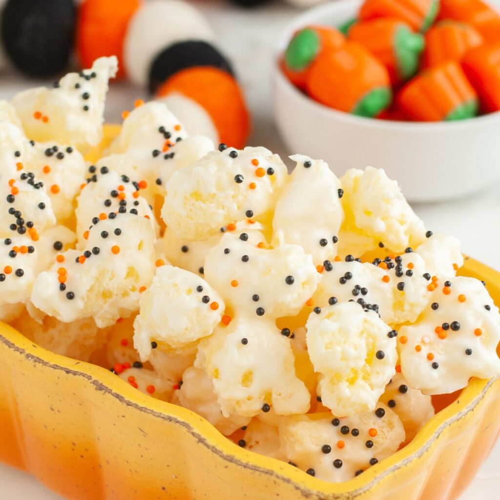 White chocolate covered puffcorn with orange and black sprinkles. 