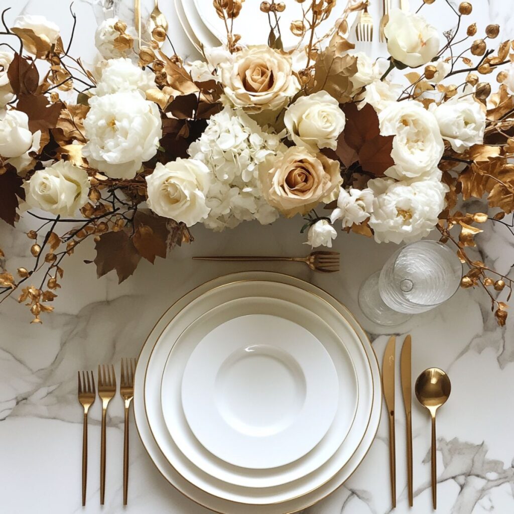 Tablescape with white and gold flowers and plates. 