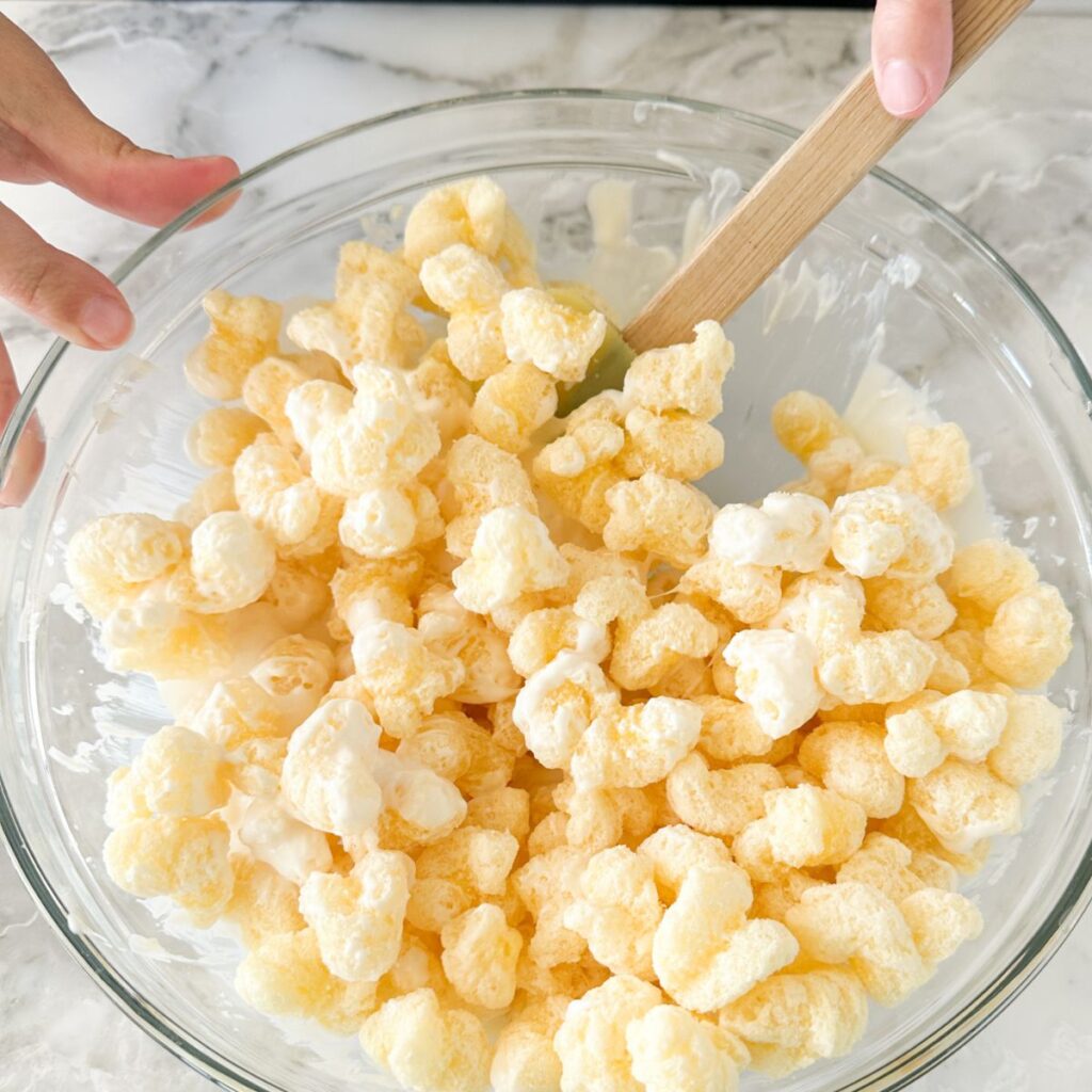 Bowl with melted white chocolate and puffcorn. 