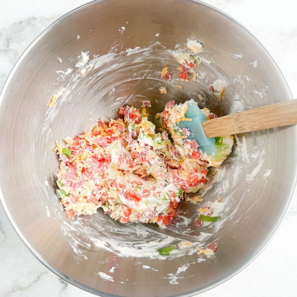 Mixing bowl with cream cheese and vegetable mixture.