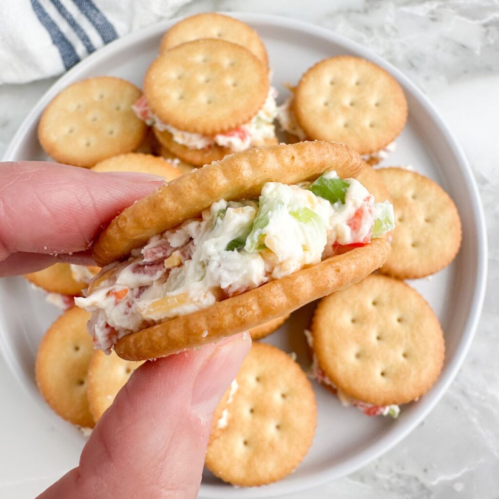 Hand holding a Ritz party cracker.