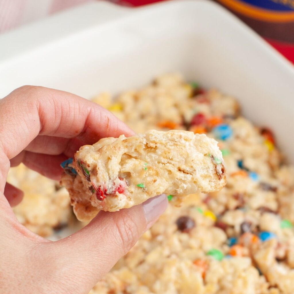 Hand holding ritz marshmallow treat. 