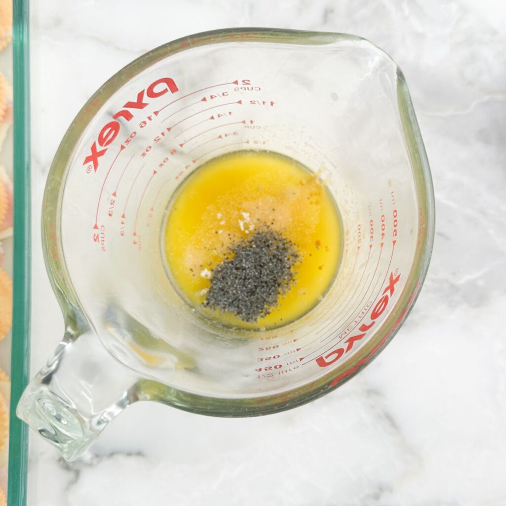 Measuring cup with melted butter and seasonings. 