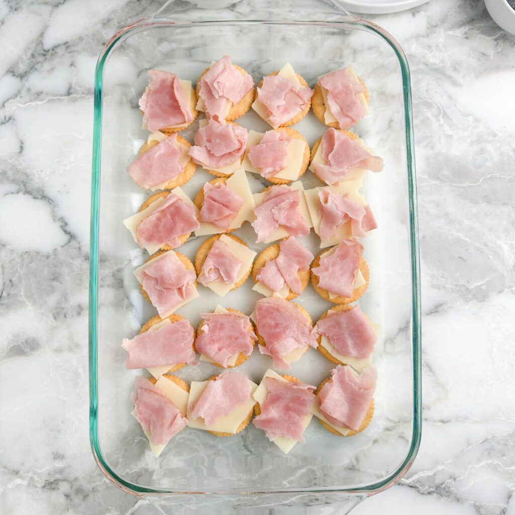 Ritz crackers topped with cheese and pieces of ham. 