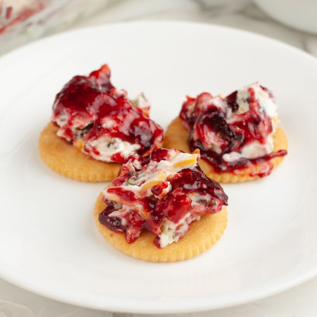 Crackers with raspberry dip on a plate. 