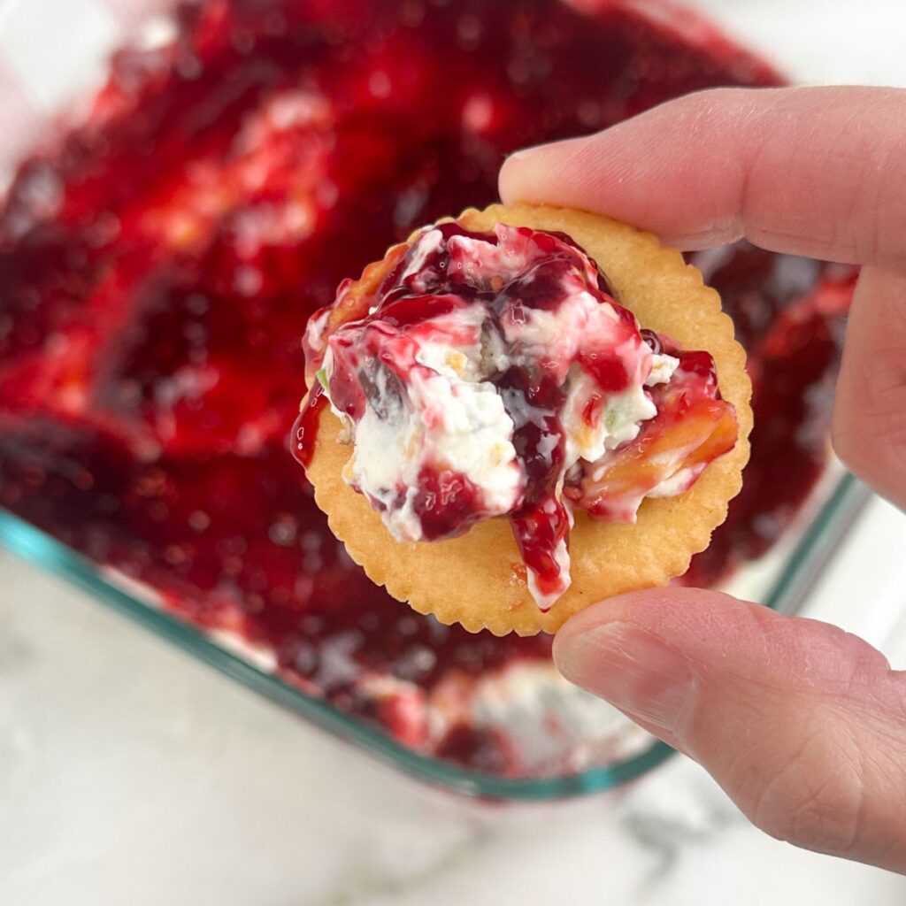 Cracker with raspberry cream cheese dip. 