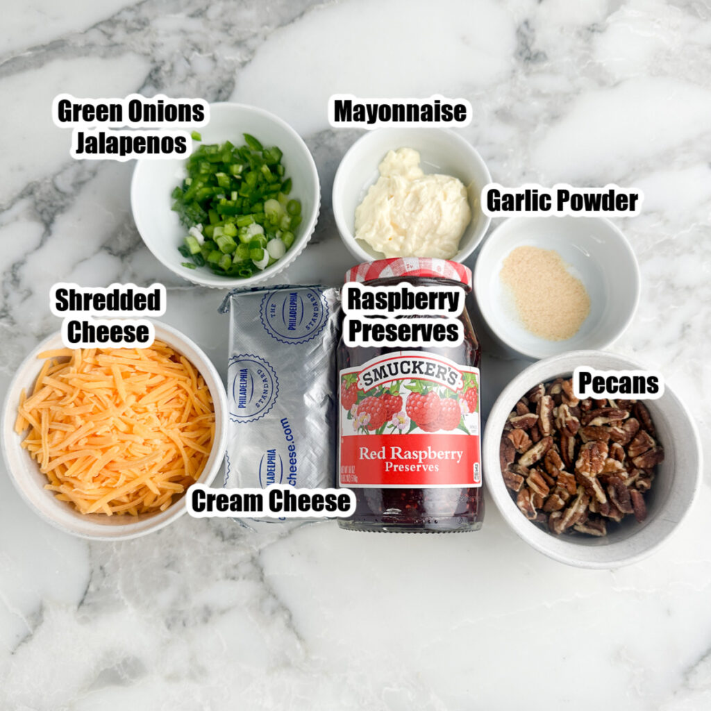 Bowl of shredded cheese, green onions, mayonnaise, cream cheese, pecans, and raspberry preserves. 