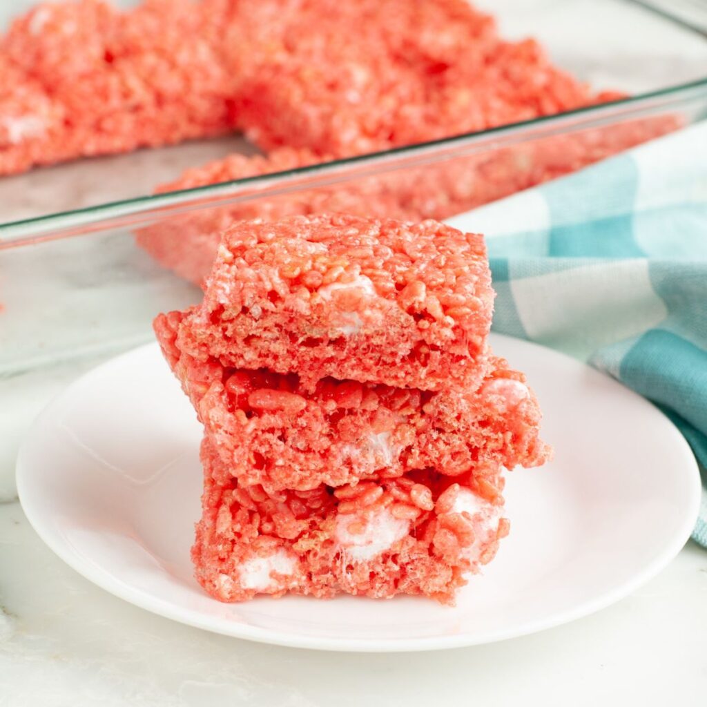 Strawberry rice krispie treats stacked on a plate. 