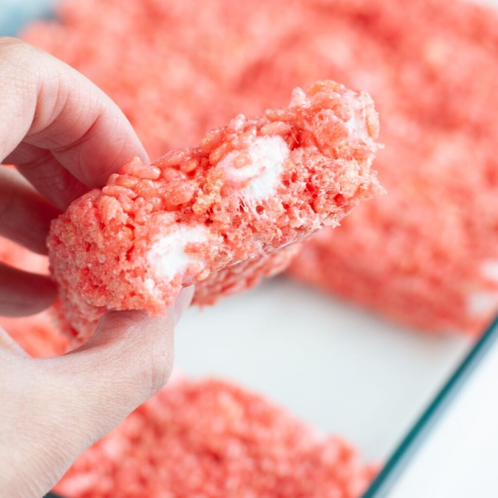 Hand holding strawberry rice krispie treats.
