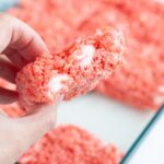 Hand holding strawberry rice krispie treats.