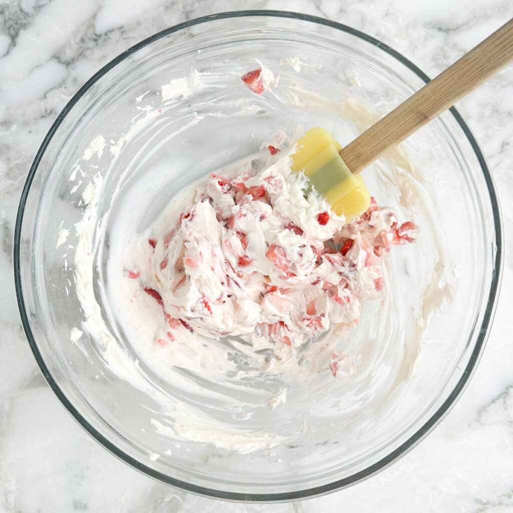 Bowl with a mixture of cream cheese and diced strawberries. 