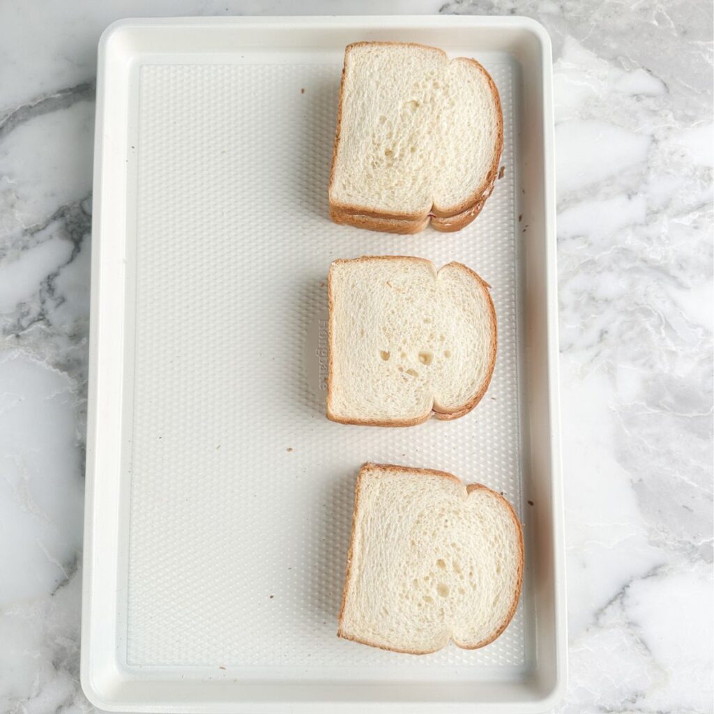 Strawberry tea sandwiches on baking pan.